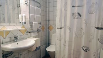 A bathroom with a sink, toilet, and shower curtain.