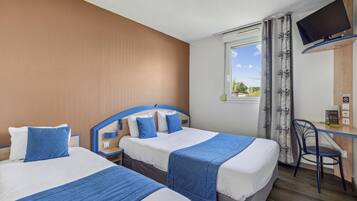 Ein Hotelzimmer mit zwei Betten, einem Schreibtisch, einem Stuhl, einem Fernseher und einem Fenster mit Vorhängen.