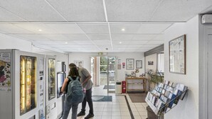 A hallway with vending machines, a bulletin board with flyers, and a door leading to another room. - Hôtel Akena City Châteaurenard (Chateaurenard)