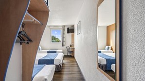 A narrow corridor with two beds, a desk, and a mirror reflecting the room. - Hôtel Akena City Châteaurenard (Chateaurenard)