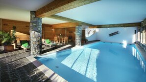 A swimming pool with stone pillars, wooden beams, and a stone floor. - Hôtel l'Autantic (Bourg-Saint-Maurice)