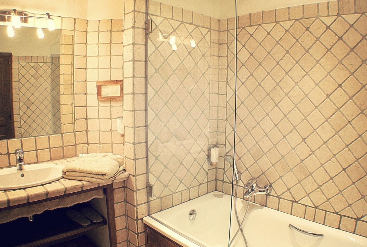 Un baño con lavamanos, espejo y ducha.
