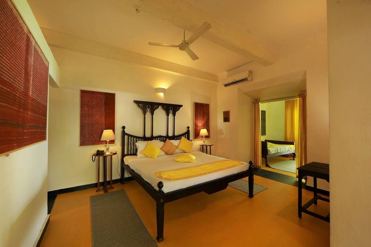 A bedroom with a bed, bedside tables, a ceiling fan, and a mirror.