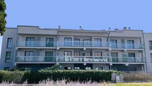 A multi-story residential building with balconies, a flat roof, and a clear sky. - Maestrale Resort Hotel - Alberese, Grosseto (Grosseto)