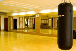 Une salle de sport équipée d’un sac de frappe, de planchers en bois et de murs recouverts de miroirs.