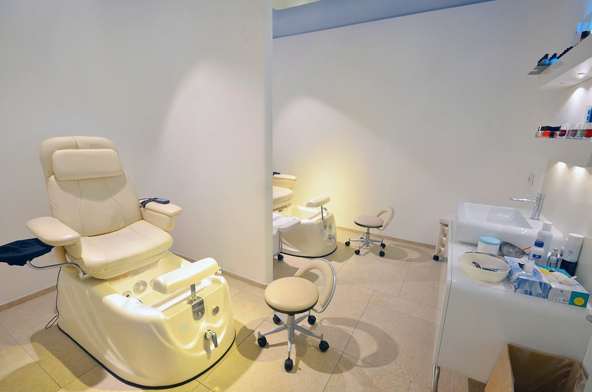 Una clínica dental con un sillón dental reclinable, un sillón dental adicional y una zona de lavado con diversos suministros.