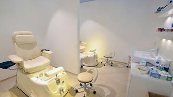 Una clínica dental con un sillón dental reclinable, un sillón dental adicional y una zona de lavado con diversos suministros.