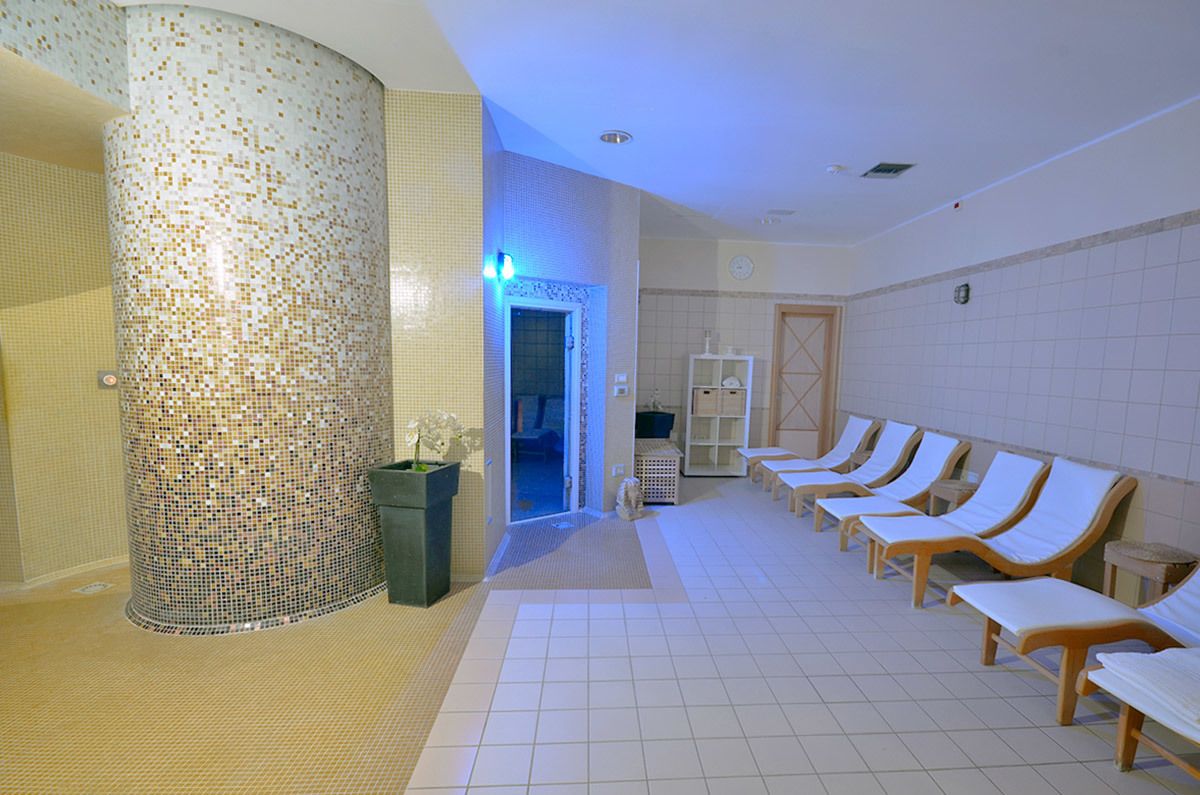 A spa area with a mosaic column, a reception desk, and lounge chairs.