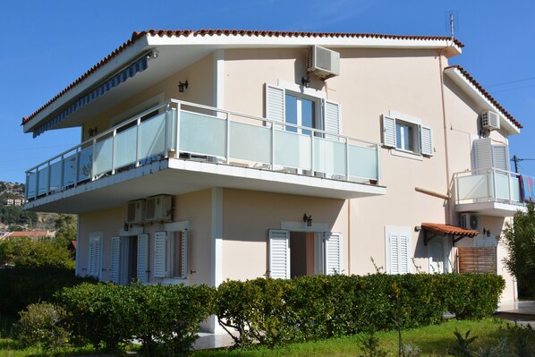 Un immeuble de deux étages doté de balcons, de climatiseurs et d’un toit plat.