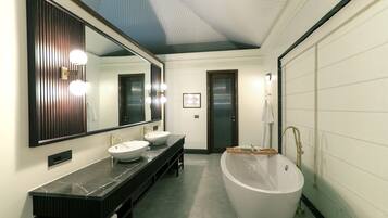 A modern bathroom with a large mirror, two sinks, a bathtub, and a shower.