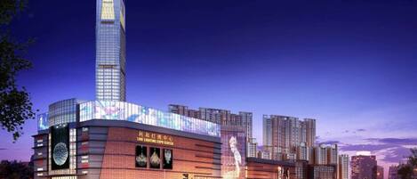 A modern building with a prominent tower and a large illuminated facade.
