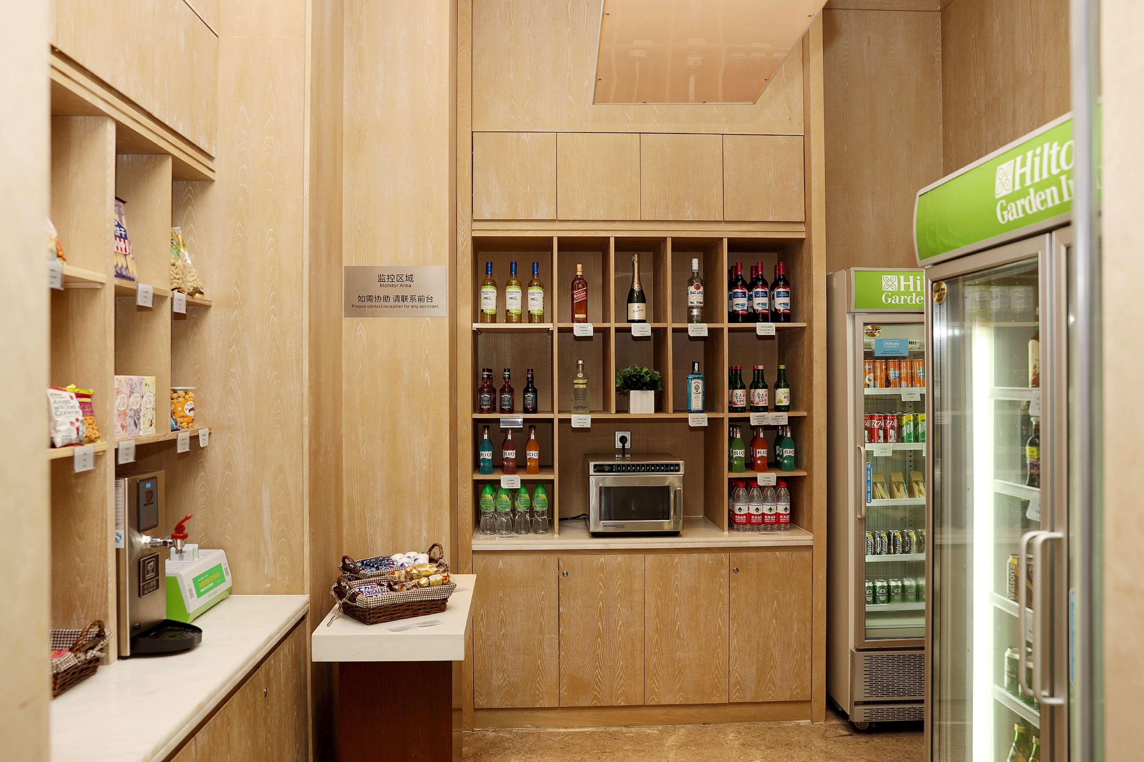 A minibar area with a variety of beverages, snacks, and a microwave.