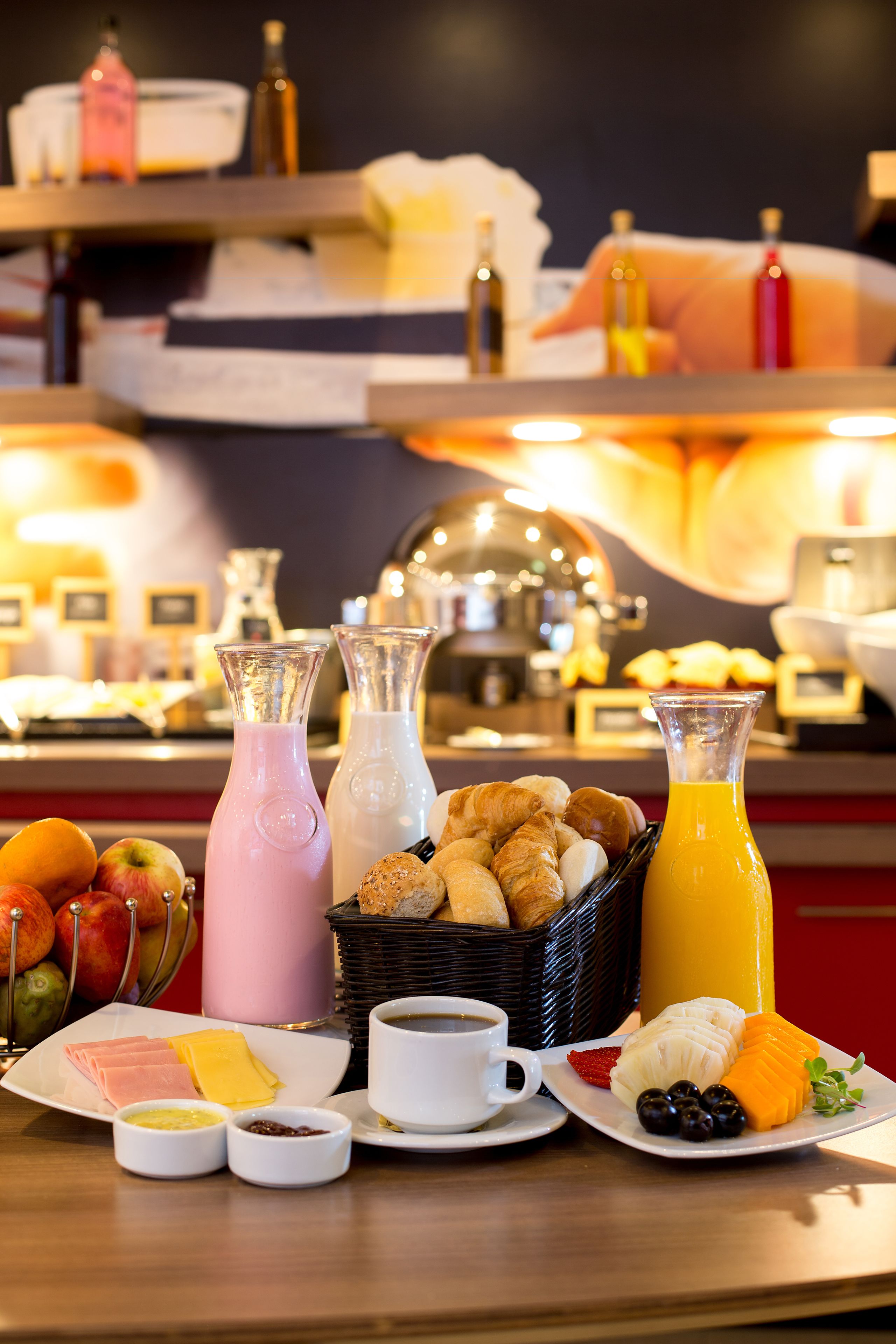 Um buffet de café da manhã com diversos alimentos, bebidas e acompanhamentos.