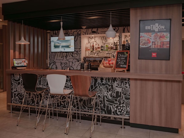 A bar area with a counter, bar stools, and a menu board. - ibis Lima Reducto Miraflores (Lima)