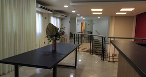 A hotel lobby with a reception desk, a staircase, and a potted plant. - Marsala Apart Hotel (Mogi das Cruzes)