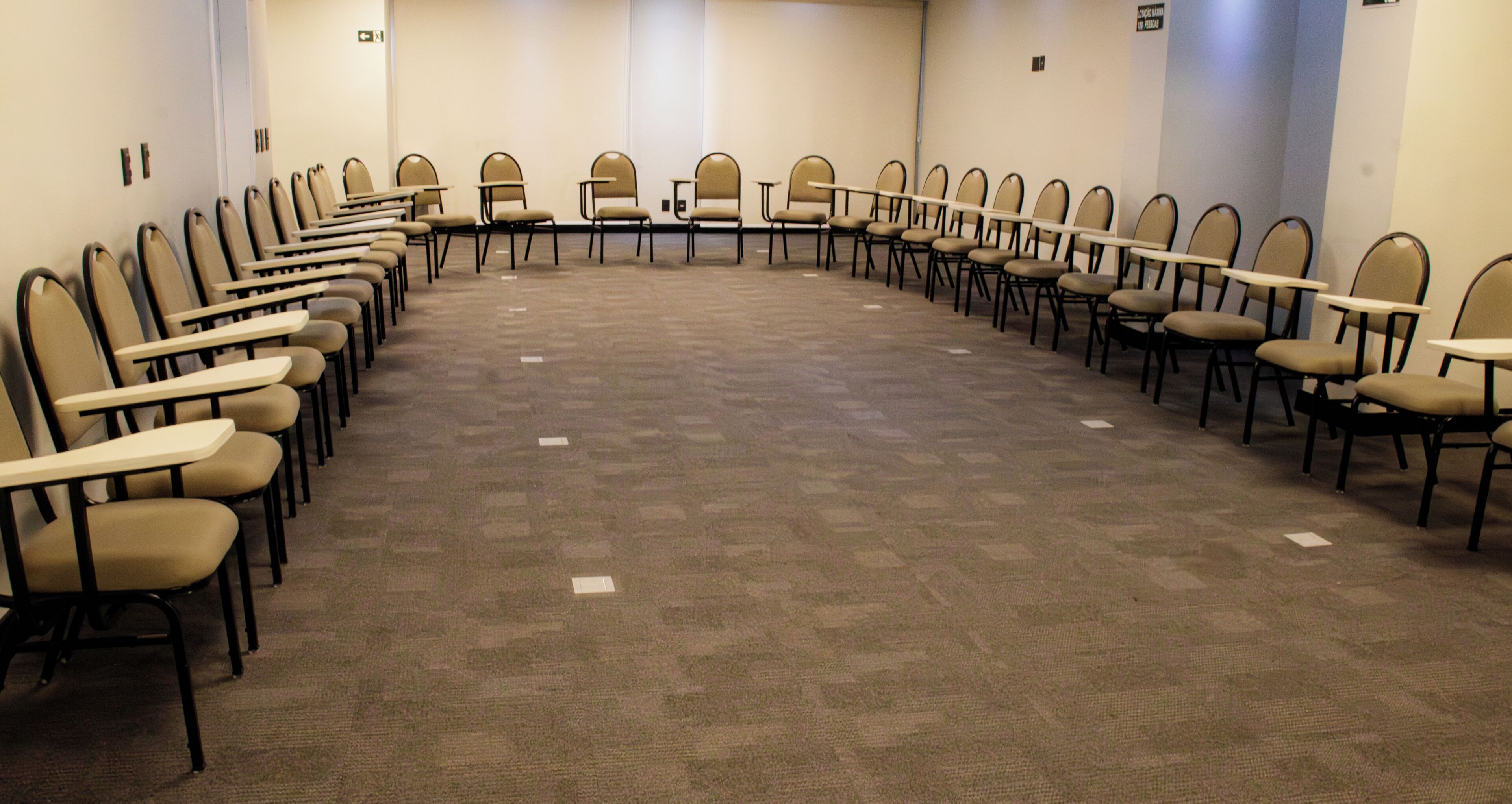 Un salón de conferencias con una larga mesa y sillas dispuestas en semicírculo.