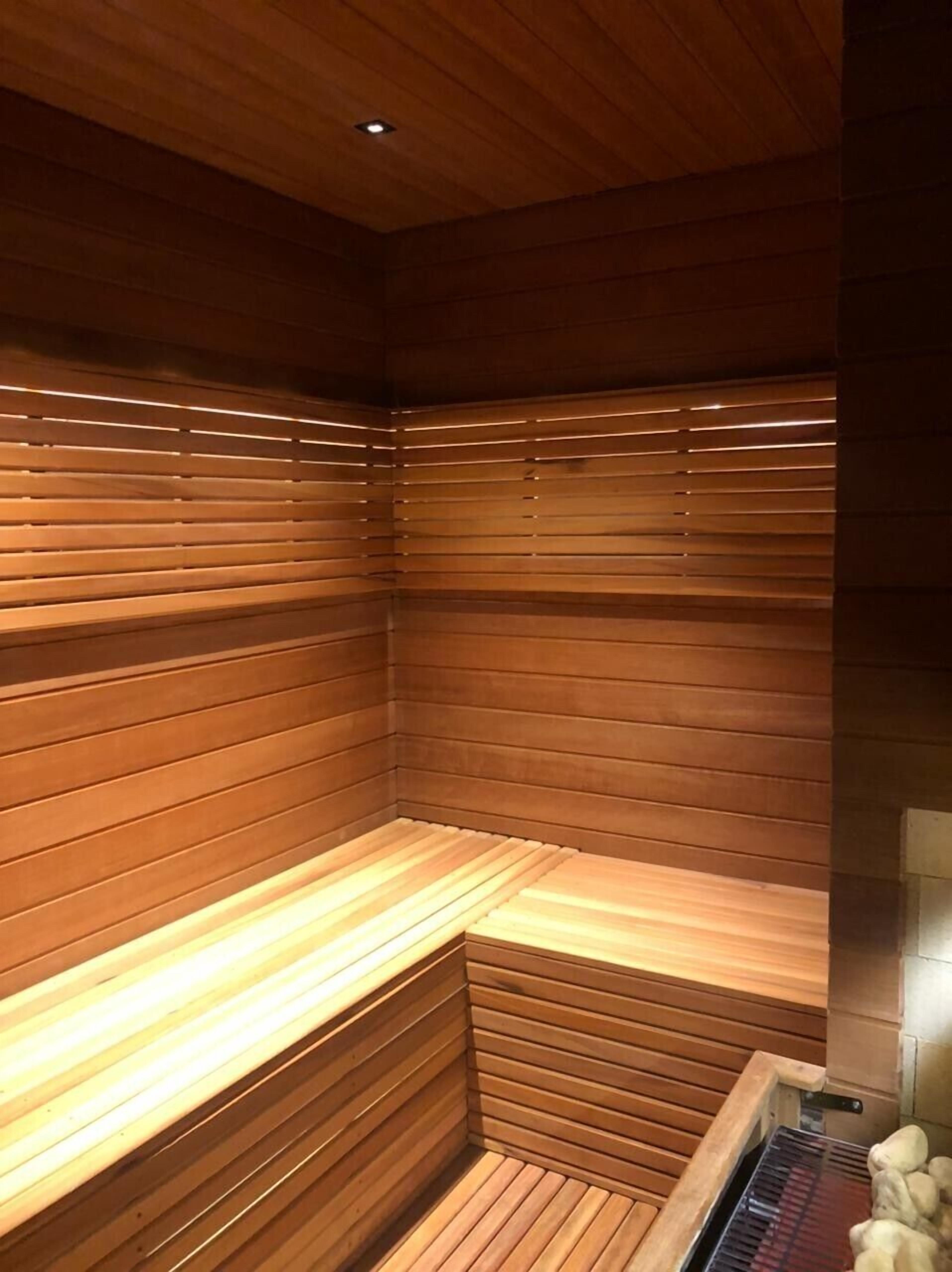 A sauna with wooden benches and a heat source.