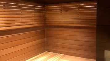 A sauna with wooden benches and a heat source.