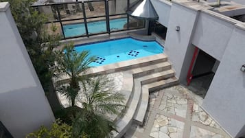 Een buitenzwembad en ligstoelen