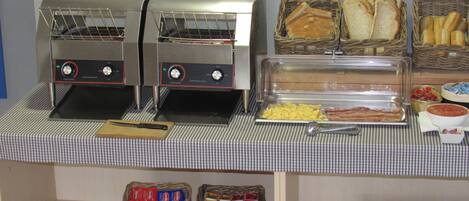 Ein Buffet mit zwei Toastern, Brotkörben und Beilagen.