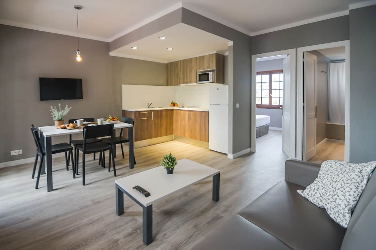 Ein modernes Wohnzimmer mit einer Couch, einem Couchtisch und einem Essbereich mit Tisch und Stühlen.