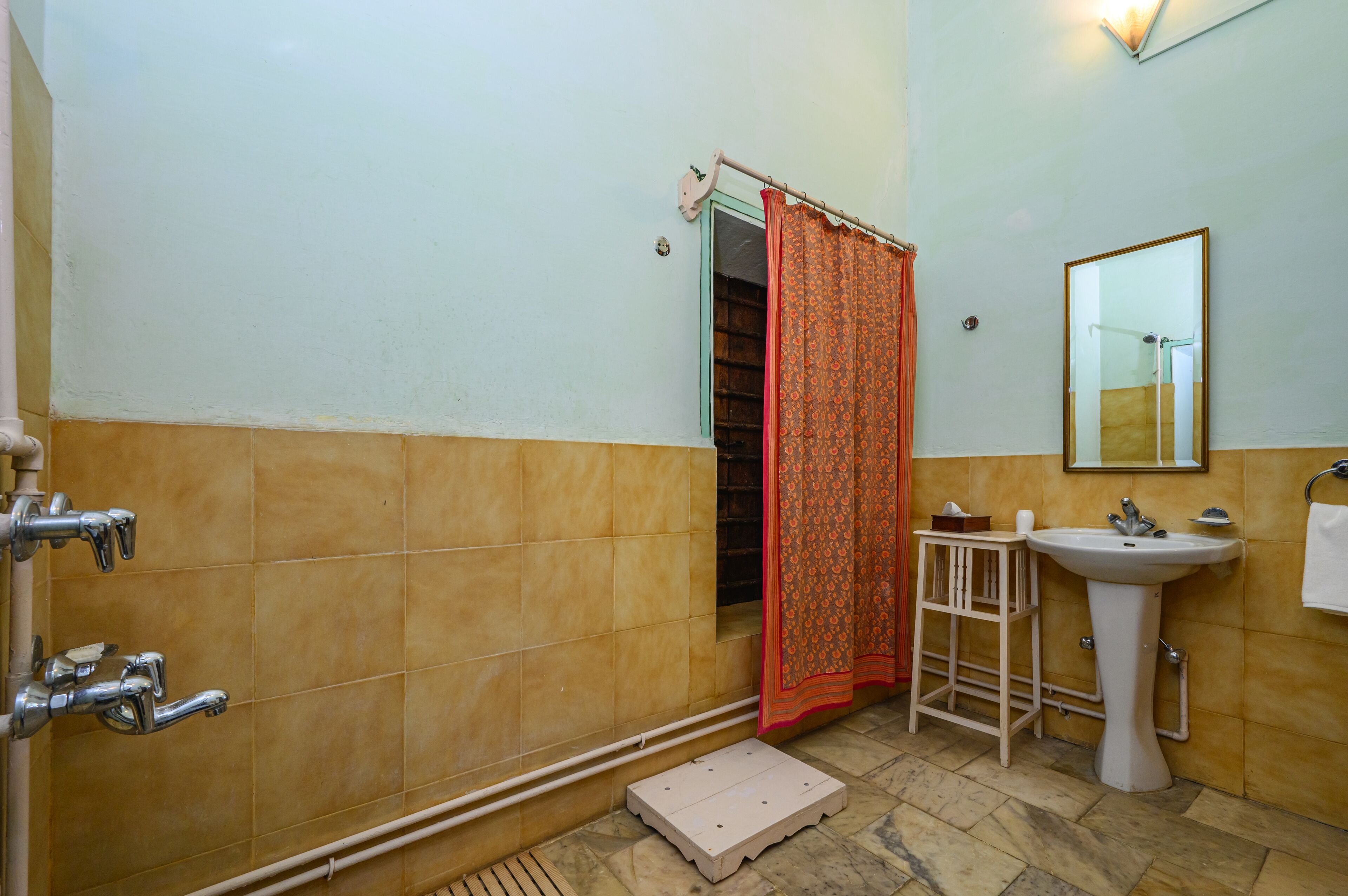 Un baño con ducha, lavamanos y espejo.
