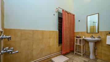 Un baño con ducha, lavamanos y espejo.