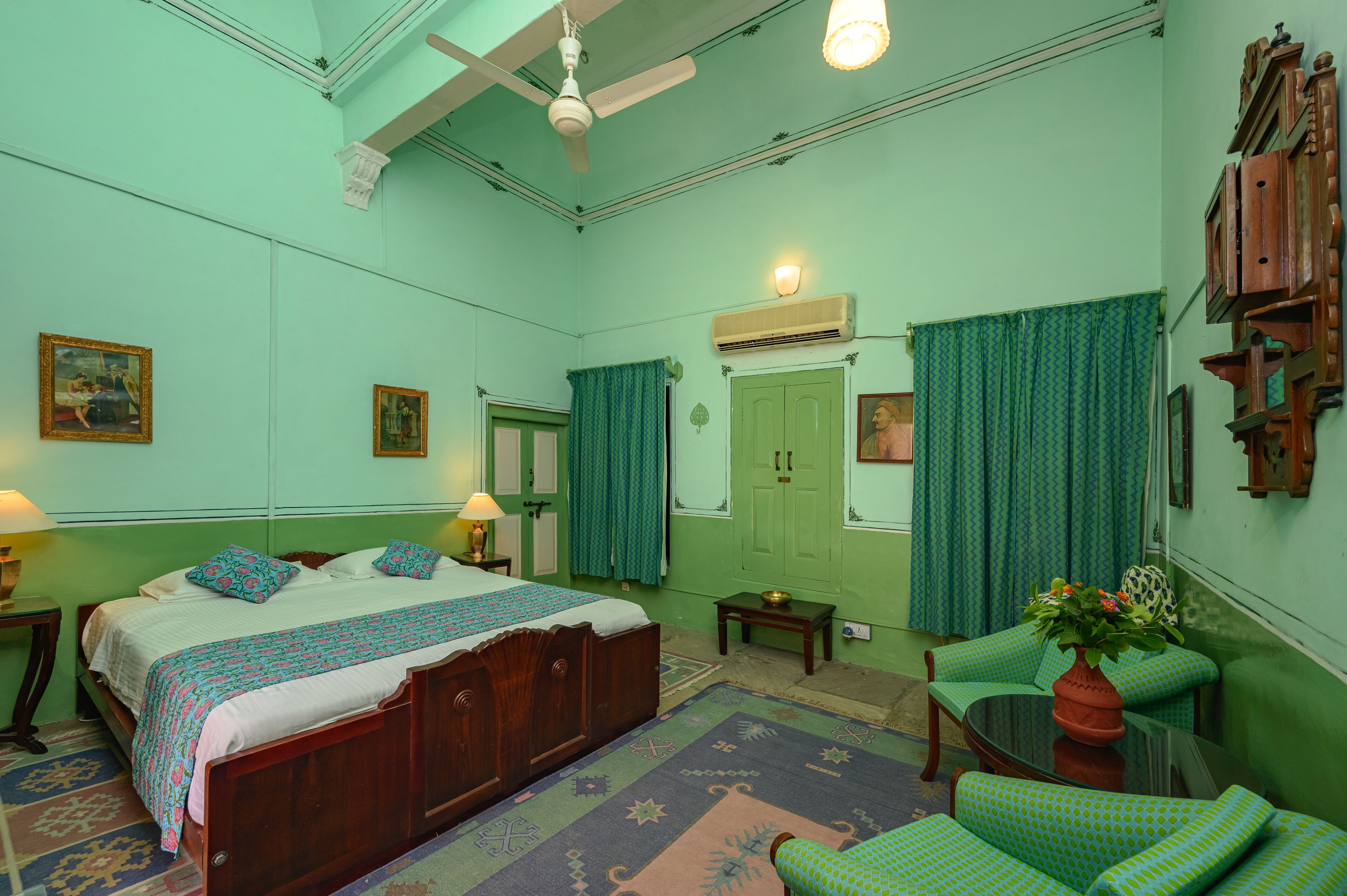 Una habitación con una cama, una silla, una mesa y un aire acondicionado de pared.