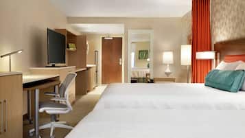 A hotel room with a bed, desk, chair, television, and lamps.