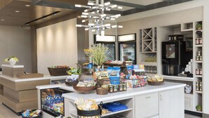 Una cocina moderna con una isla central repleta de bocadillos, bebidas y condimentos.