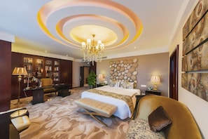 A bedroom with a large bed, a chandelier, a bookshelf, and a decorative wall.
