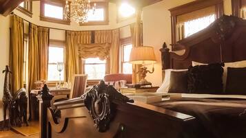 Um quarto luxuoso com uma cama grande, móveis ornamentados e um candelabro.