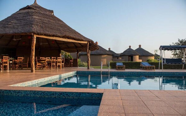 Een buitenzwembad en ligstoelen