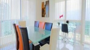 A modern conference room with a glass table, white walls, and large windows. - Miami Luxury Suite in Downtown Brickell (Miami)
