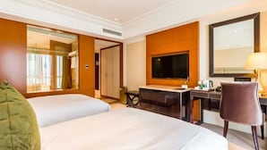 A hotel room with two beds, a desk, a television, and a mirror. - Beijing Jizhong Taurus Hotel (Beijing)