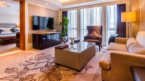 A modern hotel room with a large bed, a sitting area with a sofa and armchairs, a flat-screen TV mounted on the wall, and a large window with curtains. - Beijing Jizhong Taurus Hotel (Beijing)