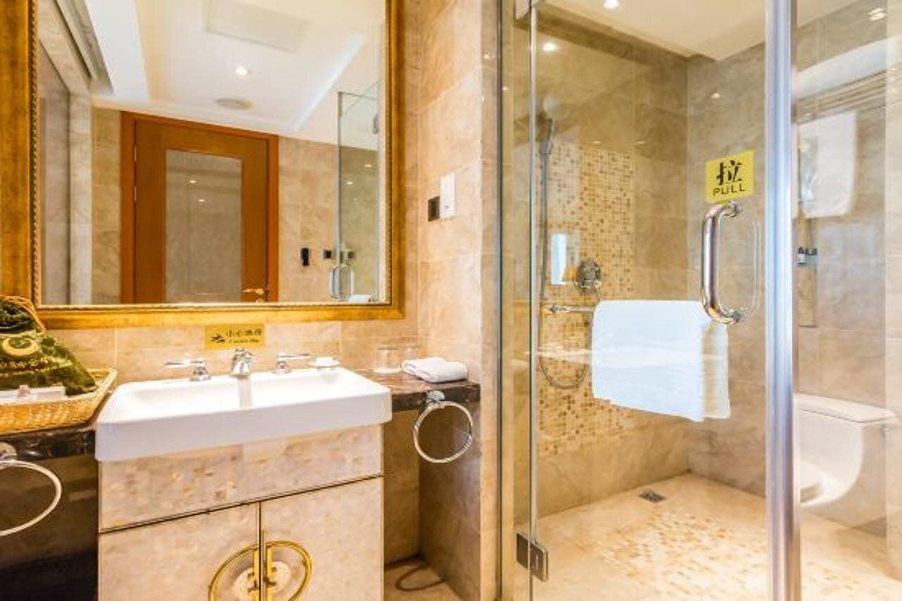 A modern bathroom with a glass-enclosed shower, a sink, and a mirror.
