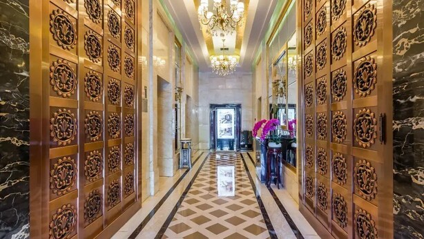A luxurious hallway with ornate wall panels, a chandelier, and a patterned floor. - Beijing Jizhong Taurus Hotel (Beijing)