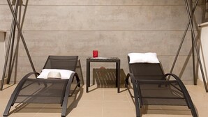A room with two reclining chairs, a small table with a red object, and a white pillow on one chair. - Malaga Apartments Andes (Málaga)