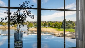 Vista a través de una ventana con un florero, un lago y un campo de golf.