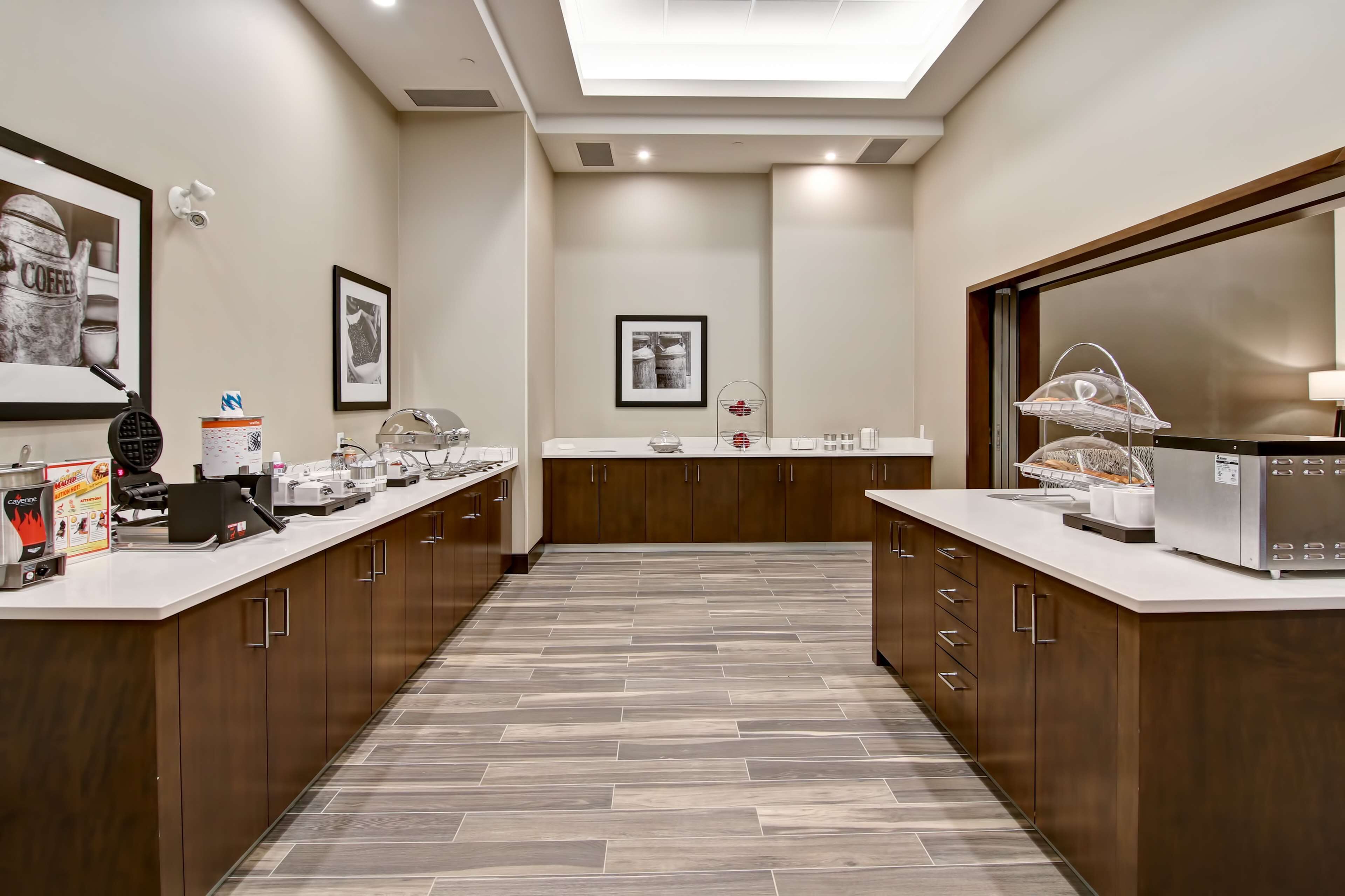 A modern kitchen with a central island, wooden cabinets, and a tiled floor.