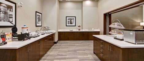 A modern kitchen with a central island, wooden cabinets, and a tiled floor.