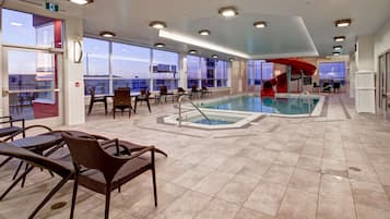Una piscina techada, sillones reclinables de piscina