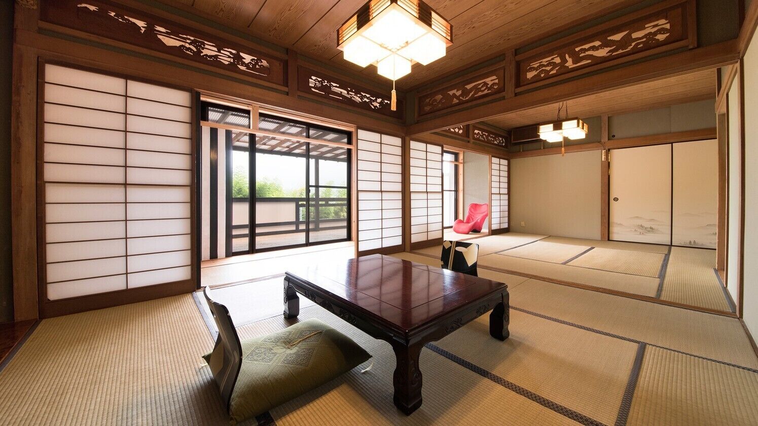 Una tradizionale stanza giapponese con pavimento in tatami, un tavolo di legno e porte scorrevoli.