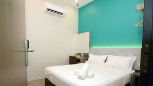 Una habitación de hotel con cama, escritorio y aire acondicionado.