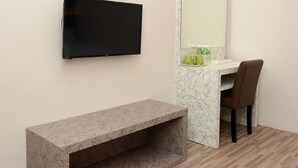 Un baño moderno con un televisor de pantalla plana montado en la pared, encimera de mármol, un banco y una silla.