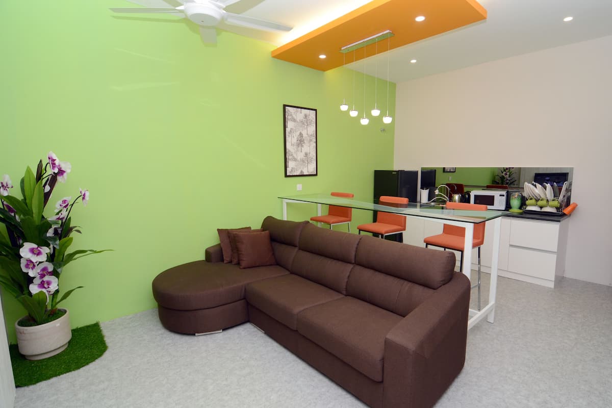 Una sala de estar moderna con un sofá seccional marrón, una mesa de centro de vidrio y una pequeña planta en maceta.