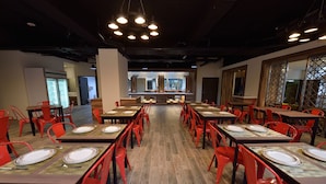 A spacious dining area with multiple tables and red chairs, featuring a modern design with exposed ceilings and natural light from large windows. - Home Rest Hotel (Taitung)
