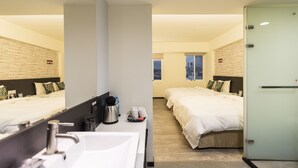 A hotel room with a large bed, a separate bed, a bathroom with a sink, and a mirror. - Home Rest Hotel (Taitung)