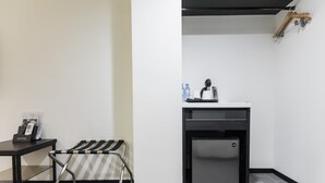 A compact kitchenette with a refrigerator, a coffee maker, and a water dispenser on the counter. - Home Rest Hotel (Taitung)